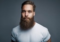 Bearded young man standing confidently against a gray background - PhotoDune Item for Sale