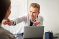 Male beautician touching woman face at laptop during consultation - PhotoDune Item for Sale
