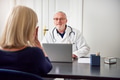 Medical consultant sitting and listening to patient at computer - PhotoDune Item for Sale