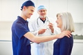 Young medic encouraging adult woman patient in hospital - PhotoDune Item for Sale