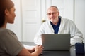 Senior doctor talking to young woman in clinic - PhotoDune Item for Sale