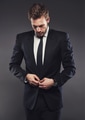 Stylish businessman in a suit standing aganst a grey background - PhotoDune Item for Sale