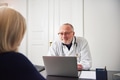 Woman in hospital talking with therapist sitting at laptop - PhotoDune Item for Sale