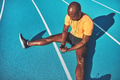 Young athlete sitting on a running track listening to music - PhotoDune Item for Sale