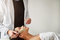 Cosmetologist putting mask on young woman in salon - PhotoDune Item for Sale