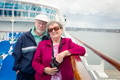Senior Adult Couple Enjoying The View From Their Passenger Cruise Ship with Their Bonoculars. - PhotoDune Item for Sale