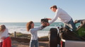 Group Of Young Friends On Road Trip Unpacking Convertible Car At The Beach With Ocean In Background - PhotoDune Item for Sale