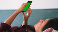 Close Up Of Woman Lying On Sofa At Home Using Green Screen Mobile Phone - PhotoDune Item for Sale