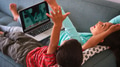 Over The Shoulder Shot Brother And Sister Sitting On Sofa At Home Using Laptop Computer Together - PhotoDune Item for Sale
