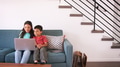 Brother And Sister Sitting On Sofa At Home Using Laptop Computer Together - PhotoDune Item for Sale