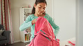 Smiling Young Girl Packing Bag Ready For School In Bedroom - PhotoDune Item for Sale