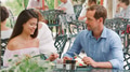 Mid Adult Couple Sitting At Table Enjoying Meal At Outdoor Cafe Or Restaurant - PhotoDune Item for Sale