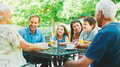 Multi Generation Family Sitting At Table Enjoying Snack At Outdoor Cafe Or Restaurant - PhotoDune Item for Sale