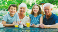 Portrait Of Grandparents With Grandchildren At Table Enjoying Snack At Outdoor Cafe Or Restaurant - PhotoDune Item for Sale
