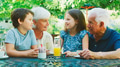 Grandparents With Grandchildren At Table Enjoying Snack At Outdoor Cafe Or Restaurant - PhotoDune Item for Sale