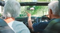 Rear View Of Senior Couple On Road Trip In Convertible Car Driving Along Tree Lined Road - PhotoDune Item for Sale