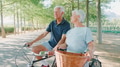 Senior Retired Couple On Vacation Cycling Along Tree Lined Country Road In Summer - PhotoDune Item for Sale
