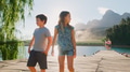 Family On Vacation Standing On Wooden Jetty By Lake With Mountains In Background - PhotoDune Item for Sale