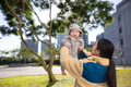 Mother lifting baby outside on sunny day - PhotoDune Item for Sale