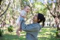 Loving mother lifting happy baby in park - PhotoDune Item for Sale