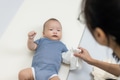 Mum clean baby hand on bed - PhotoDune Item for Sale