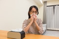 Woman sneezing at home in living room - PhotoDune Item for Sale