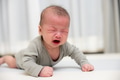 Upset baby crying on soft mat at home - PhotoDune Item for Sale
