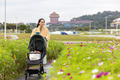 Mother walking with baby stroller in flower park - PhotoDune Item for Sale