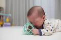 Infant crying and crawling with teether on mat - PhotoDune Item for Sale