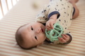 Baby rolling crawling and chewing teether on bed - PhotoDune Item for Sale