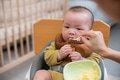 Baby enjoying first solid food meal - PhotoDune Item for Sale