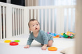 Cute baby crawling on soft play mat in white crib - PhotoDune Item for Sale