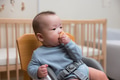 Baby sitting in chair holding snack - PhotoDune Item for Sale