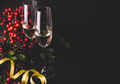 Champagne and christmas decoration with conifer tree, red berries and pinecone on black background - PhotoDune Item for Sale