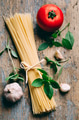 Italian pasta food ingredients on rustic wooden table Top view of spaghetti garlic tomato and basil - PhotoDune Item for Sale