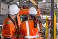 Robotic technician engineer male training helping young women team control operate robot welding arm - PhotoDune Item for Sale