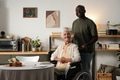 Portrait of Black Man Assisting Senior Caucasian Woman in Wheelchair Indoors - PhotoDune Item for Sale