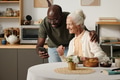 Young Black Man Showing Smartphone to Senior Caucasian Woman Smiling - PhotoDune Item for Sale