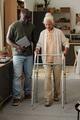 Young Black Man Assisting Senior Caucasian Woman Using Walker Indoors - PhotoDune Item for Sale