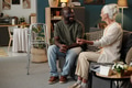 Black Man Talking with Senior Caucasian Woman Indoors - PhotoDune Item for Sale
