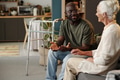 Black Man Talking with Senior Caucasian Woman in Living Room - PhotoDune Item for Sale