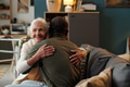 Senior Caucasian Woman Embracing Young Black Man in Living Room - PhotoDune Item for Sale
