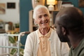 Senior Caucasian Woman Smiling While Talking with Black Man - PhotoDune Item for Sale