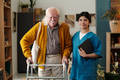 Portrait of Senior Man Using Walker Assisted by Young Adult Female Nurse - PhotoDune Item for Sale