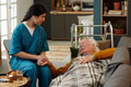 Young Adult Hispanic Woman Comforting Senior Caucasian Man Lying on Sofa - PhotoDune Item for Sale