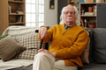Portrait of Senior Caucasian Man Sitting on Sofa Holding Cane and Looking Confident - PhotoDune Item for Sale