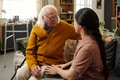 Senior Caucasian Man Smiling While Talking with Young Adult Latin Woman - PhotoDune Item for Sale