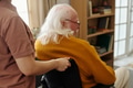 Senior Caucasian Man with Disability Sitting in Wheelchair Being Assisted - PhotoDune Item for Sale
