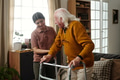 Young Adult Latin Woman Assisting Senior Caucasian Man Using Walker Indoors - PhotoDune Item for Sale