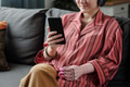 Caucasian Young Adult Woman with Prosthetic Hand Using Smartphone on Sofa - PhotoDune Item for Sale